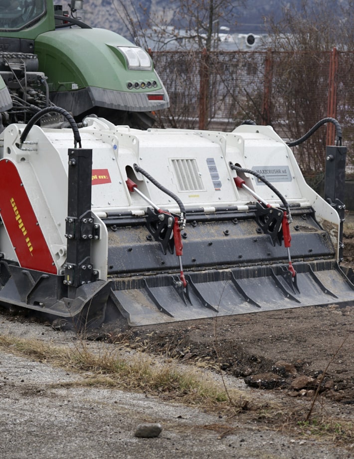 MAXICRUSHR xd mit  zweiteiliger hydraulische Heckklappe - 1. Haube mit integriertem Brechraster mit separater Einstellung für Regulierung der Korngröße, 2. Haube dient als Planierschildf ür glattes und ebenes Ergebnis.